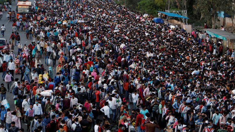 People wait to board buses in New Delhi